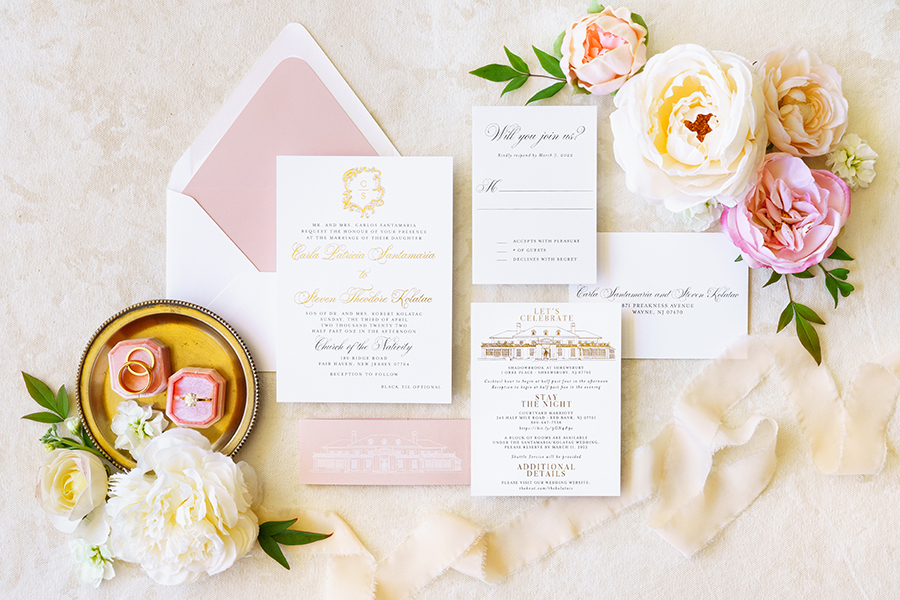 Custom wedding invitation suite with metallic gold foil stamping, blush envelope liner, blush belly band, and venue illustration of the Shadowbrook